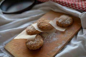 Homemade vegan patties placed on a rustic wooden board with parchment paper, styled in a cozy kitchen setting. Warm natural light highlights the texture, ideal for food photography or plant-based meal