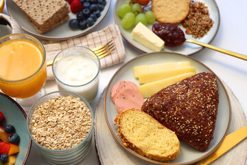 Assortment of various breakfast foods and drinks on the white table. Selective focus.