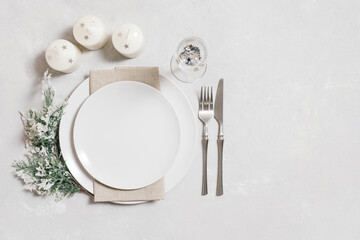 Christmas serving with empty white plate, candles and silverware on white background. Beautiful New...