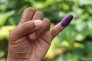 Man showing little finger after voting on Indonesia's presidential election, isolated on blurred...