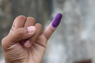 Man showing little finger after voting on Indonesia's presidential election, isolated on blurred background