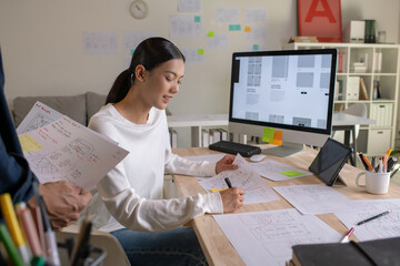 UX UI designers discussing and brainstorming on wireframes for a website and mobile app prototype, in the concept of website and mobile application design concept.