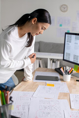 UX UI designer working on wireframes for a website and mobile app prototype, surrounded by sketches...