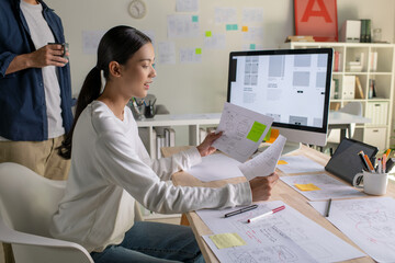 UX UI designers discussing and brainstorming on wireframes for a website and mobile app prototype, in the concept of website and mobile application design concept.