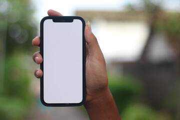 hand holding android smartphone with blank white screen with clipping path, isolated on blurred background