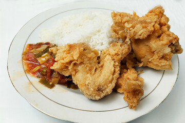 Rice mixed with flour fried chicken on a white plate on the table