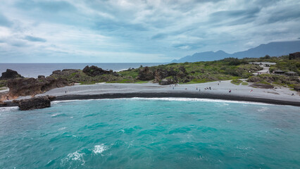 Visitors explore the stunning coastal landscape of Sanxiantai in Taiwan during a cloudy day