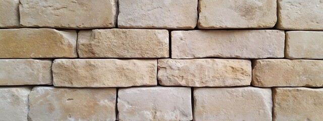 Fototapeta premium An image of beige sandstone wall cladding, with multiple horizontal overlapping bricks