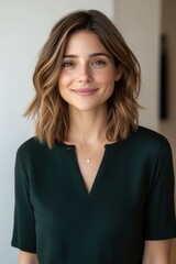 Woman with shoulder-length hair smiles warmly indoors