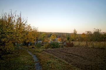 Naklejka premium Dirt road through the village in autumn