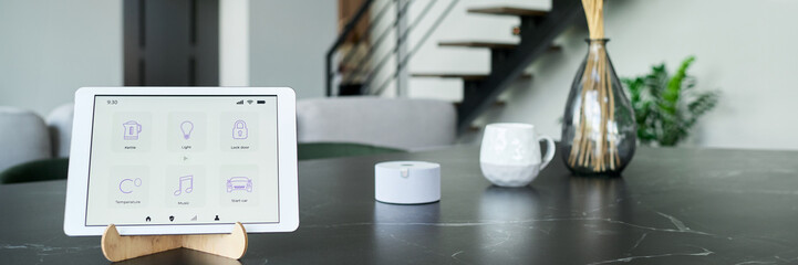 Modern interior featuring tablet displaying smart home control interface on wooden stand on marble table, enhancing convenience and connectivity in daily life