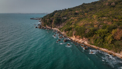 Obraz premium Taiwan coast features a rocky shoreline and lush greenery by tranquil blue waters