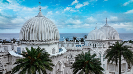Obraz premium Beautiful architectural domes overlooking the ocean and palm trees in Taiwan during a clear day