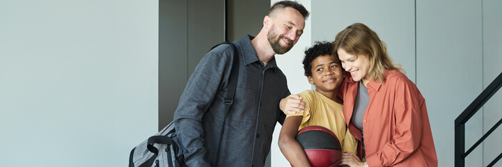 Family sharing joyful embrace with each other indoors holding ball highlighting loving relationship and unity smiling and happy expressions