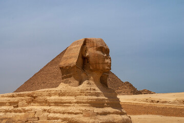 Great Sphinx in front of Pyramid of Cheops (Khufu). Giza Pyramid Complex is complex of ancient...