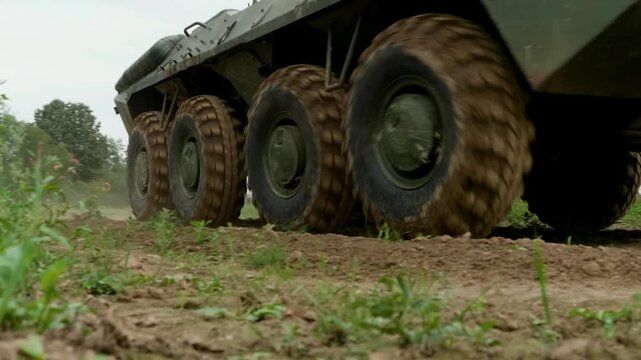 The armored personnel carrier moves across a military proving ground, demonstrating its amphibious capabilities and robust design, intended for transporting personnel and providing fire support.
