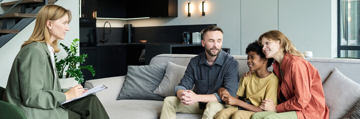 Family of three receiving counseling and support from a professional therapist in a modern living...