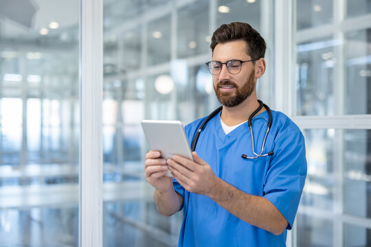 Doctor using tablet in hospital setting. Medical professional smiling while utilizing digital technology for healthcare. Stethoscope around neck symbolizes commitment to care.