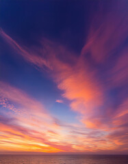 Obraz premium Dreamy sunset horizon painted in violets and pinks, soft orange and peach tones. Wispy cloud trails