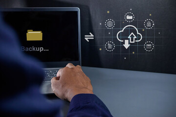 Businessman using a laptop to upload data to cloud storage. Data backup and cloud data storage concept.
