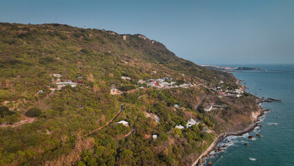 Coastal view of lush hills and tranquil water in Kaohsiung, Taiwan during daylight