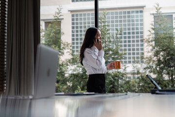 Fototapeta premium Professional Businesswoman in Modern Office Environment with Laptop and Coffee