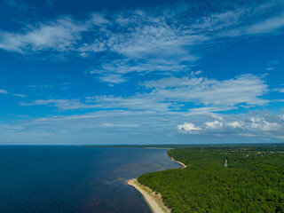 Aerial view of calm and wild Turisalu beach with a clear white sand (Estonian - Türisalu rand) on a sunny summer day. Big rocks in a calm and green Baltic sea. 