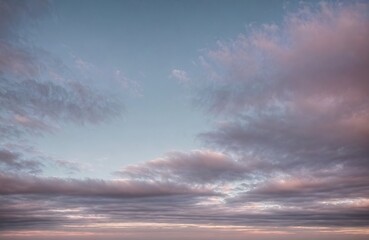Obraz premium Cloudy sky with pink and blue tones at sunset.