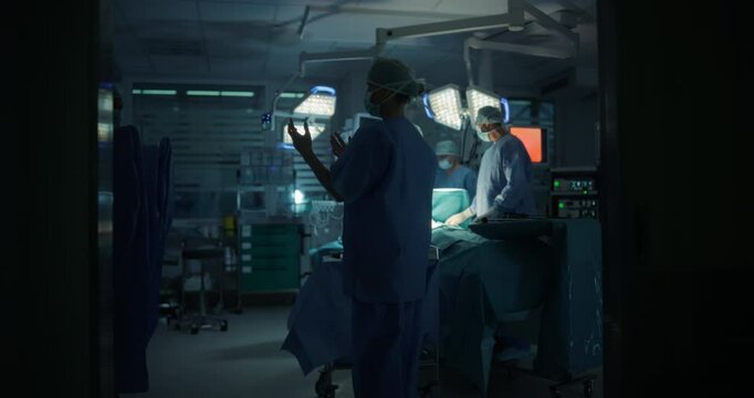 Female Surgeon Enters a Modern Operating Room with Professional Medical Personnel, Nurse Helping to Put On a Protective Gown on the Doctor. Team is Ready for the Surgery and Save Patient's Life