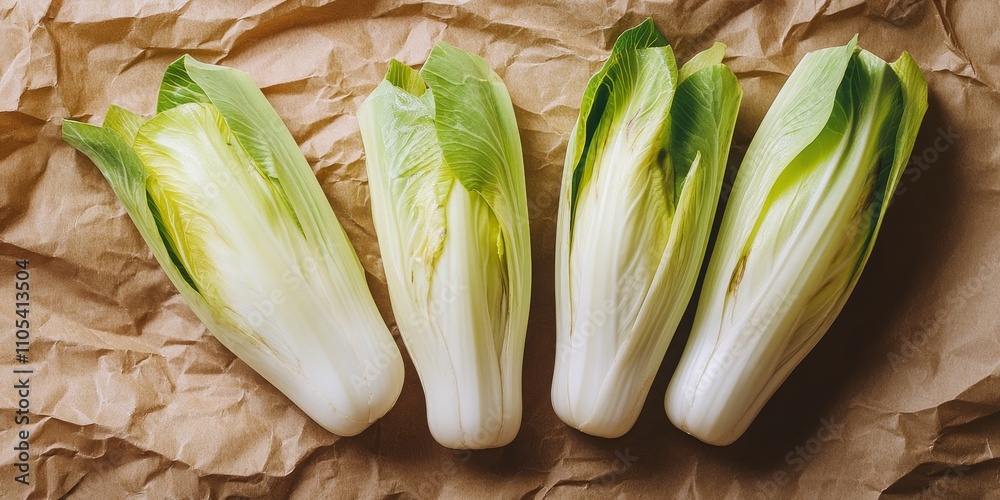 Poster fresh green endive displayed on crumpled brown craft paper from a top view perspective, highlighting