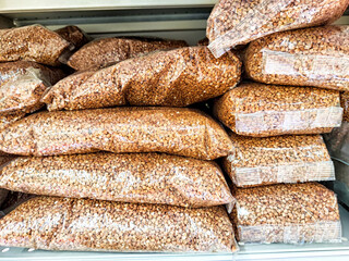 Bags of dry red lentils stacked neatly in a grocery store aisle during daylight hours