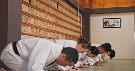 Bow, respect and people in martial arts studio for practice, training or self defense class. Culture, karate and group of students with greeting or etiquette gesture to master in dojo for honor. © peopleimages.com