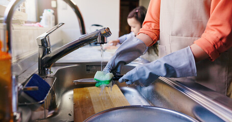 Hands, girl and mom for washing dishes in home, learning and helping hand for hygiene in kitchen. People, mother and daughter with routine, teaching and cleaning for dirt at family house in Japan