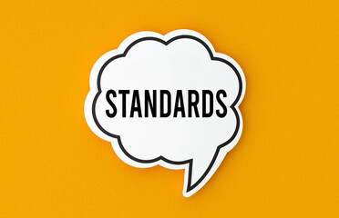 Standards concept written in a speech bubble. Yellow background, illustration.