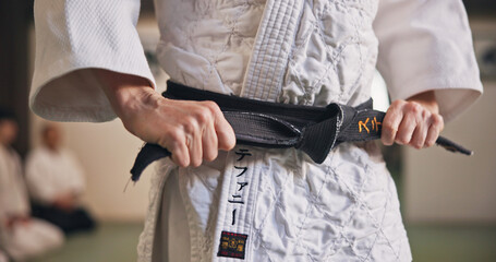 Person, hands and black belt for karate with exercise, ready and prepare for training in Japan studio. Man, martial arts or professional fighter in dojo for sport, expertise or sensei in self defense © peopleimages.com