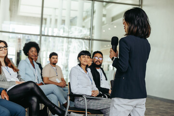 Asian business woman speaker giving a presentation at a conference with an engaged audience