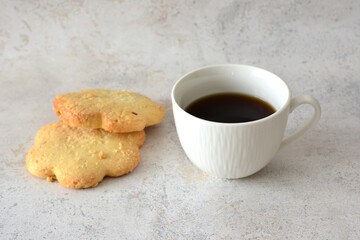 a cup of coffee next to some sugar cookies