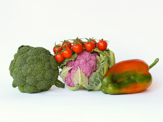 Fresh vegetables isolated on white background. Sicilian Broccoli, pink cauliflower, pepper and tomatoes.
