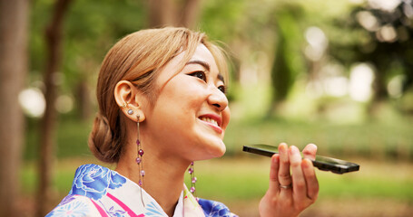 Asian woman, park and communication with phone for voice message, conversation or vocal audio in...