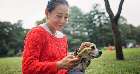 Nature, phone and woman with dog in forest for bonding, companion and love for adoption. Happy, connection and Japanese female person with beagle puppy for pet outdoor in woods for playing together.