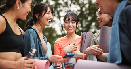 Laugh, yoga and girl friends in nature with conversation for health, wellness and balance in morning. Happy, talking and group of Japanese women outdoor for pilates workout or exercise in park.