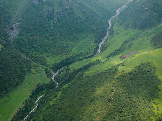 A mountain river, a stream meanders among the green slopes of the mountain. Summer landscape,...