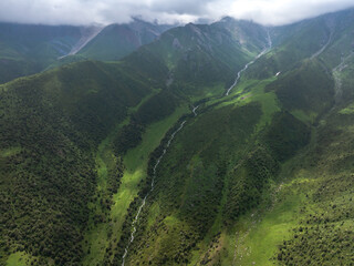 A mountain river, a stream meanders among the green slopes of the mountain. Summer landscape,...