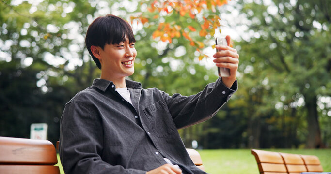 Asian man, smile and selfie in park for social media, video call and connectivity in Kyoto. Happy person, relax and outdoor in Japanese garden for photography, live streaming or virtual communication