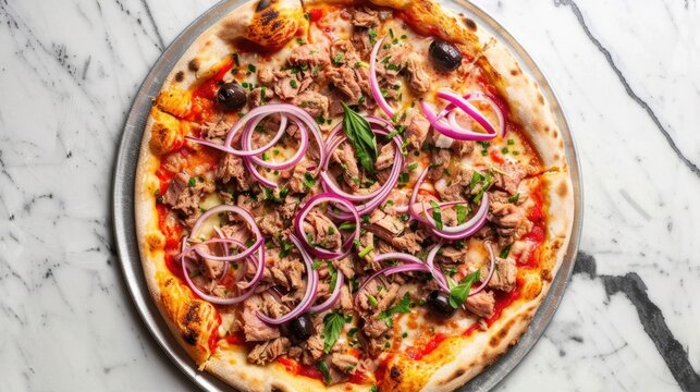 Pizza topped with tuna, red onion, olives, and tomato sauce on marble table