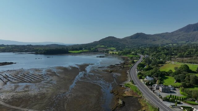 Adrigole Harbour, Beara Peninsula, County Cork, Ireland, September 2024. Drone descends and orbits counter clockwise above the coast on the Wild Atlantic Way with the Caha Mountains in the distance.