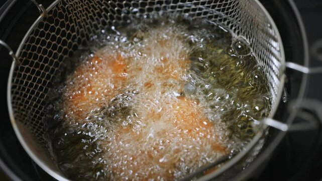 Du poulet en train de frire dans une friteuse