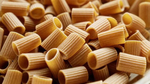 Closeup detailed shot of uncooked short pasta tubes, showcasing texture and shape for culinary or recipe use