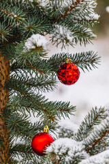 Christmas tree is adorned with vibrant red ornaments and a soft layer of snow