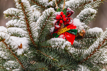 Christmas tree is adorned with vibrant red ornaments and a soft layer of snow
